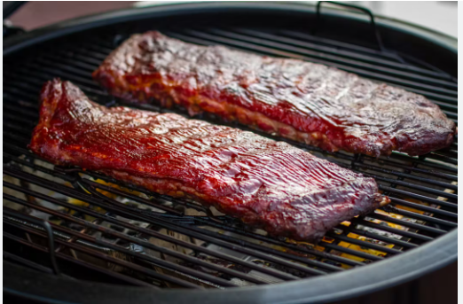 barbecuing ribs on a charcoal grill